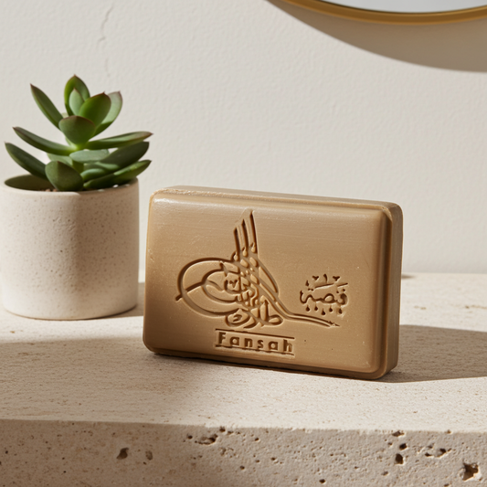 Rose Scented Aleppo Laurel Soap — beige bar of Aleppo soap on a stone surface, with a potted succulent