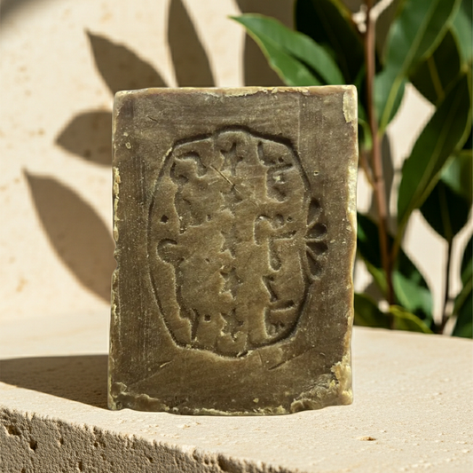 Original Aleppo Laurel Soap by Fansa 8% — tan bar of Aleppo soap standing upright on a stone surface