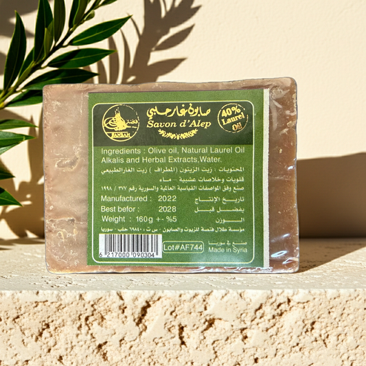 Original Aleppo Laurel Soap by Fansa 40% — beige bar of Aleppo soap in its paper wrapper on a stone surface