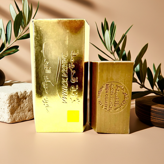 Oud Musk Aleppo Soap by Dakka Kadima — two amber bars displayed on a stone surface, with an olive branch