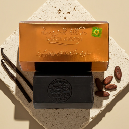 Vanilla & Chocolate Musk Aleppo Soap by Dakka Kadima — bar shown beside its gold box on a textured stone slab