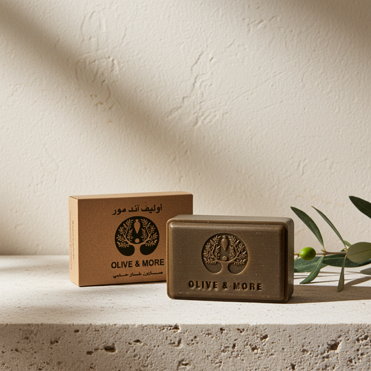 Aleppo Laurel Soap — two dark brown bars displayed on a textured stone slab, with leaves