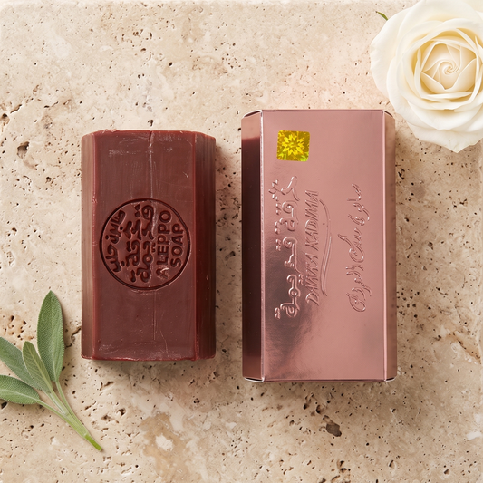 Musk of the Bride Aleppo Soap by Dakka Kadima — two burgundy bars displayed on a textured stone slab, with green leaves