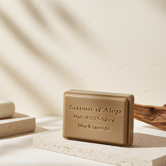 Oud Scented Aleppo Laurel Soap — beige bar of Aleppo soap on a stone pedestal